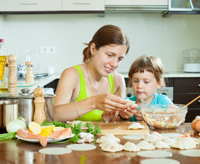 woman with a girl cooking red fish dumplings together at home ki