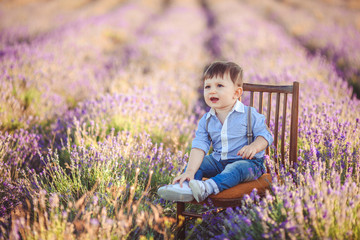 Little fashionable boy having fun in lavender summer field. 