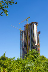 High-rise building skyscraper and cranes under construction