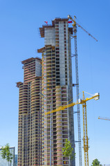 Fototapeta na wymiar Inustrial construction cranes working on building a skyscraper