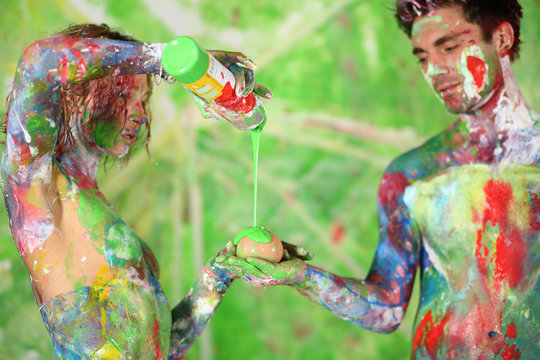 Naked man with girl all in paint poured paint on toy teat