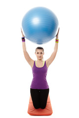 Fototapeta premium Athletic woman holding a ball and doing stretching