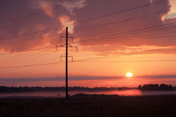 Fototapeta na wymiar High voltage power lines, fog and sunset