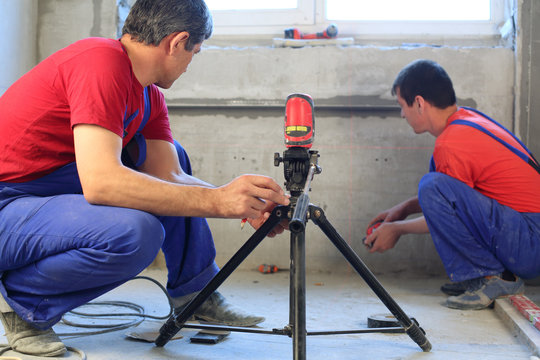 Workers Makes Measurements With Laser Level Tool