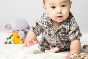 Baby boy in shirt with knitted toys in studio