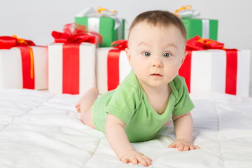 A beautiful baby girl with a gift box on the floor in studio