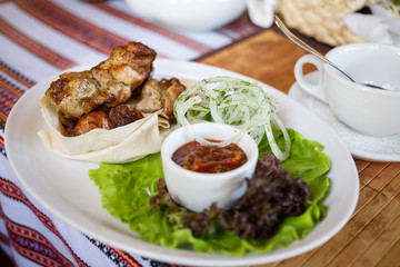 Juicy meat with onions served with a sauce.