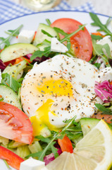 Vegetable salad with poached egg on a plate, vertical, closeup