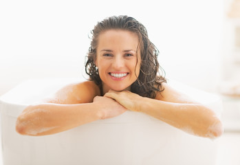 Portrait of smiling young woman in bathtub