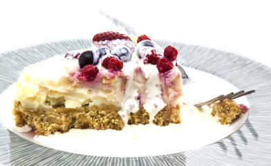 Plate of home made strawberry and fresh berry cheesecake on a wh