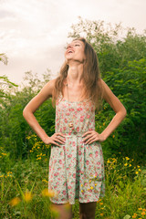 Naklejka na ściany i meble Beautiful Young Woman in Meadow of Flowers.