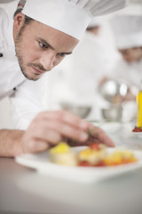 closeup on chef garnishing a plate