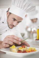 closeup on chef garnishing a plate