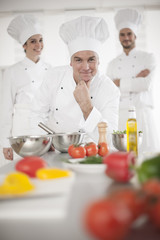 portrait of a senior chef and his team