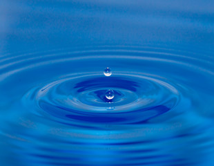 Naklejka na ściany i meble kropla wody spada na niebiesko wody