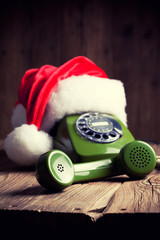 vintage phone with Santa's hat on wooden background