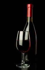 red wine glass and a wine bottle over black