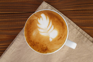 freshly made cup of cappuccino with leaf art