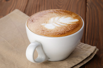 freshly made cup of cappuccino with leaf art