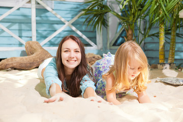 mother with the daughter plays in the resort, the sea