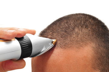 man cutting his hair with an electric hair clipper - obrazy, fototapety, plakaty