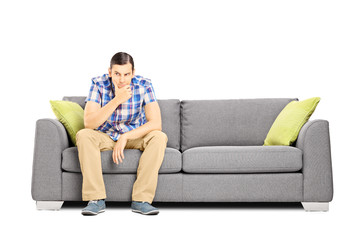Worried young businessperson sitting on a sofa