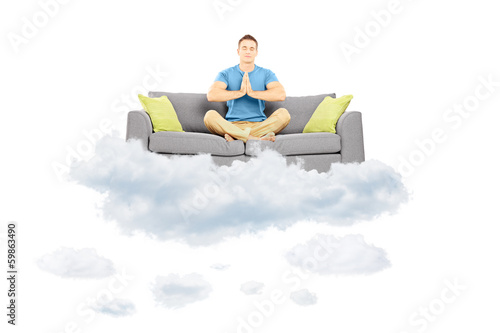 Guy Meditating On A Sofa And Floating On A Cloud Stock Photo And