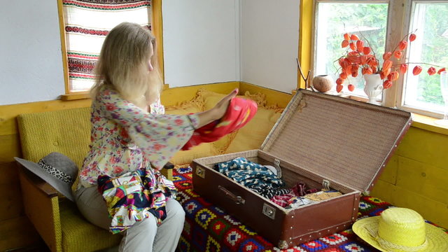 woman girl sit on armchair and flex her summer clothes to trunk