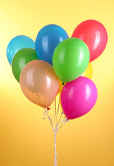 Colorful balloons on yellow background