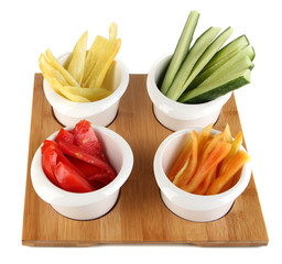Bright fresh vegetables cut up slices in bowls isolated on