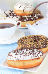 Sweet donuts with cup of tea on table close-up