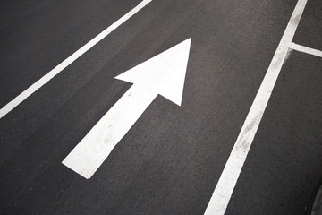 Pavement arrow on dark asphalt 
