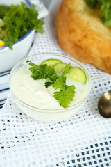 Cucumber yogurt in glass bowl and homemade bread,