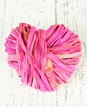 Decorative heart of straw, on wooden background © Africa Studio