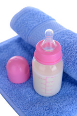 Baby bottle with milk and towel close-up