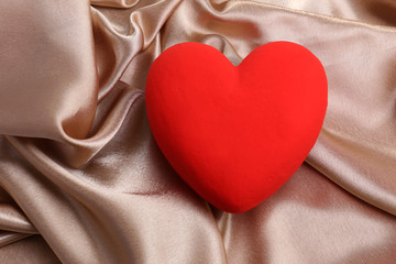 Decorative red heart, on color fabric background