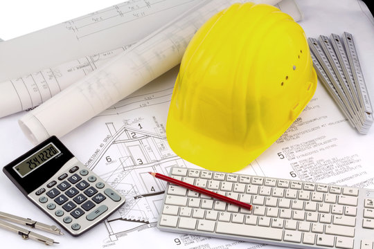 Hausplan mit Helm eines Bauarbeiters