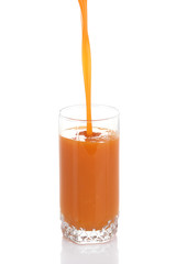 Juice pouring into glass isolated on white