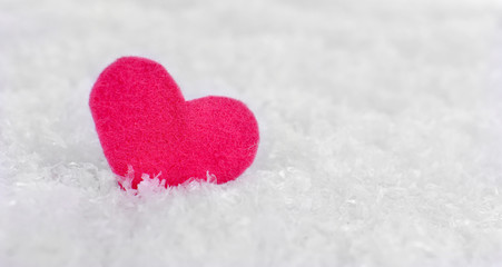Fototapeta premium Little felt heart on snowy background