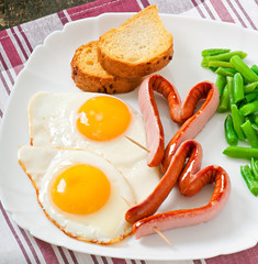 Fried eggs with sausage and green beans