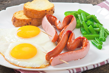 Fried eggs with sausage and green beans