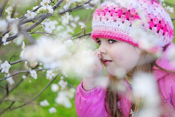 beautiful little girl near a flowering tree