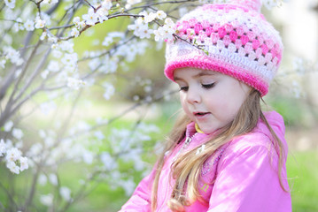 beautiful little girl near a flowering tree