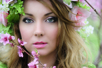 Naklejka premium Beautiful girl in a flowered garden peach