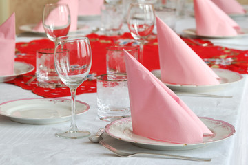 Catering table arranged with silverware and pink napkins