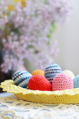 Obraz na płótnie Canvas Handmade knitted Easter eggs and lilac flower