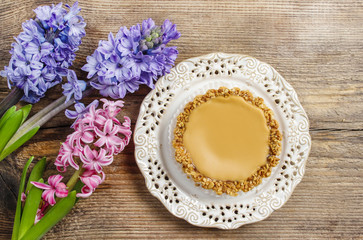 Toffee cake and hyacinth flowers on wooden table. Top view