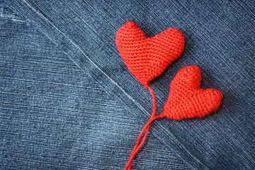Knitted heart on blue jeans texture background