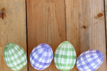Ostereier karriert auf Holzuntergrund, bunt
