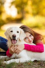 Beautiful woman and her dog posing in autumn park